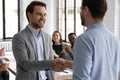 Male boss shake hand of employee congratulating with job promotion