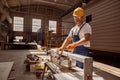 Smiling male carpenter using woodworking machine in workshop Royalty Free Stock Photo