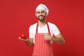 Smiling male chef cook or baker man in striped apron t-shirt toque chefs hat isolated on red background. Cooking food Royalty Free Stock Photo