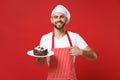 Smiling male chef cook or baker man in striped apron white t-shirt toque chefs hat posing isolated on red background Royalty Free Stock Photo