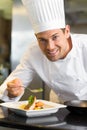 Smiling male chef garnishing food in kitchen Royalty Free Stock Photo