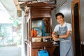 Smiling male chicken noodle seller wearing apron standing