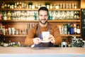 Smiling male coffee shop owner businessman standing behind the counter in the cafe Royalty Free Stock Photo