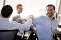 Smiling employees give fists bump greeting at workplace Royalty Free Stock Photo