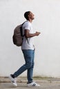 Smiling male college student walking with bag and mobile phone Royalty Free Stock Photo