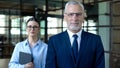 Smiling male director and female secretary looking camera, office work, business Royalty Free Stock Photo