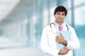 Smiling male doctor with clipboard standing in hospital hallway Royalty Free Stock Photo