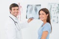 Smiling male doctor explaining lungs xray to female patient