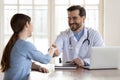 Smiling male doctor handshake female patient in hospital Royalty Free Stock Photo