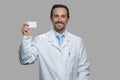 Smiling male doctor holding business card. Royalty Free Stock Photo