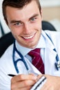 Smiling male doctor writing a perscription