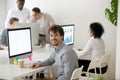 Smiling male worker looking at camera posing near office desk Royalty Free Stock Photo