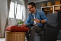 Smiling male entrepreneur with credit card doing online shopping over wireless computer on armchair Royalty Free Stock Photo