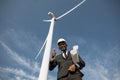 Businessman showing thumb up while posing on windmill farm