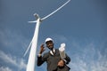 Businessman showing thumb up while posing on windmill farm