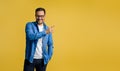 Smiling male entrepreneur pointing at copy space for marketing while standing on yellow background Royalty Free Stock Photo