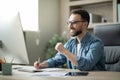 Smiling male entrepreneur using computer and taking notes at workplace in office Royalty Free Stock Photo