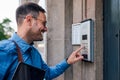 Smiling male executive using intercom while standing at entrance in the building Royalty Free Stock Photo
