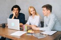 Smiling male and female colleagues working on project together. Happy Caucasian businessmen and businesswoman sitting at