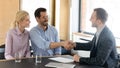 Smiling male financial advisor shaking hands with clients. Royalty Free Stock Photo