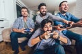 Male friends playing video games at home and having fun Royalty Free Stock Photo