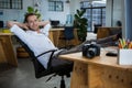 Smiling male graphic designer relaxing on the chair