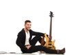 Smiling male guitarist sitting on the floor Royalty Free Stock Photo