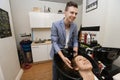 Smiling male hairstylist washing female customer's hair in salon Royalty Free Stock Photo