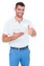 Smiling male handyman with clipboard gesturing thumbs up