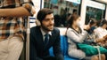 Smiling male investor listening relaxing music while sitting on train. Exultant. Royalty Free Stock Photo