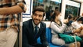 Smiling male investor listening relaxing music while sitting on train. Exultant. Royalty Free Stock Photo