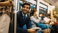 Smiling male investor listening relaxing music while sitting on train. Exultant. Royalty Free Stock Photo