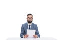 smiling male newscaster with papers looking at camera,