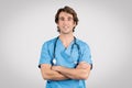 Confident male nurse in blue scrubs with arms crossed and stethoscope Royalty Free Stock Photo
