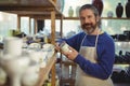 Smiling male potter holding cup in pottery workshop