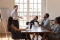 Smiling male presenter talk with excited multiethnic workers at briefing Royalty Free Stock Photo