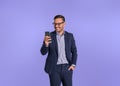 Smiling male professional chief with hand in pocket checking messages over smart phone. Young businessman dressed in formals using Royalty Free Stock Photo