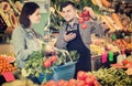 Smiling male shopping assistant helping customer to buy fruit an Royalty Free Stock Photo