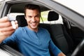 Proud new car owner. Smiling male sitting in his car holding up his car keys. Royalty Free Stock Photo