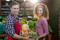 Smiling male staff assisting a woman with grocery shopping Royalty Free Stock Photo