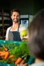 Smiling male staff assisting a woman with grocery shopping Royalty Free Stock Photo