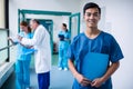 Smiling male surgeon holding a clipboard in corridor Royalty Free Stock Photo