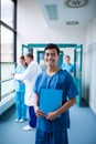 Smiling male surgeon holding a clipboard in corridor Royalty Free Stock Photo