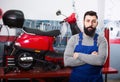 Male worker demonstrating motorbikes and scooters Royalty Free Stock Photo