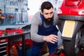 Male worker fixing failed scooter in workshop Royalty Free Stock Photo