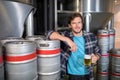 smiling male worker holding beer glass while standing at factory Royalty Free Stock Photo