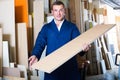 smiling male worker standing with plywood pieces Royalty Free Stock Photo