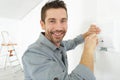 Smiling man adjusting thermostat on home heating system Royalty Free Stock Photo