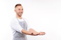 Smiling man in apron stretching out his hands Royalty Free Stock Photo