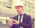 Smiling man architect in helmet working at the tablet Royalty Free Stock Photo